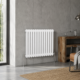 Aura 2 Column Horizontal Radiator 600x785mm White installed in a modern living space with wooden flooring and neutral décor.