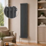 Aura 2 Column Vertical Radiator 1800x380mm Anthracite installed in a modern neutral living room with shelving and wooden flooring.