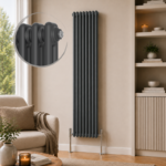 Aura 2 Column Vertical Radiator 1800x470mm Anthracite installed in a warm neutral living room with modern shelving and wooden flooring.