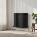 Aura 3 Column Horizontal Radiator 600x605mm Anthracite installed in a modern living space with decorative wall panelling and wooden flooring.