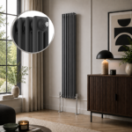 Aura 3 Column Vertical Radiator 1800x290mm Anthracite installed in a modern living room with wooden sideboard, feature lighting and large window.