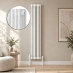 White Aura 3 column vertical radiator, 1800mm x 335mm, installed in a modern neutral living room.