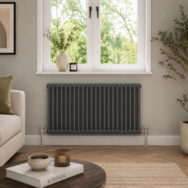 Aura 2 Column Horizontal Radiator 600x1190mm Anthracite installed beneath a window in a modern living room with wooden flooring and neutral décor.