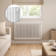 Aura 3 Column Horizontal Radiator 600x830mm White installed beneath a window in a bright modern living room with soft neutral décor.