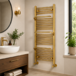 Tall brushed brass towel radiator installed in a large bathroom with multiple towels hanging from rails