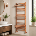 Bronze heated towel rail mounted in a warm-toned luxury bathroom with towels draped over horizontal rails