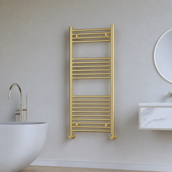 Vela brushed brass heated towel rail (1200mm x 500mm) installed in a contemporary bathroom setting with a soft brushed brass finish, showcasing its elegant vertical design and premium styling.